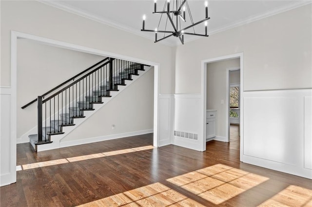 interior space with visible vents, ornamental molding, stairs, and wood finished floors