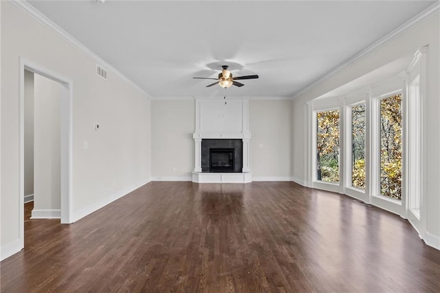 unfurnished living room with dark wood finished floors, crown molding, visible vents, and a tile fireplace