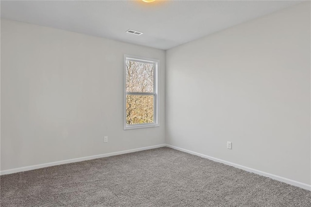 carpeted spare room featuring visible vents and baseboards