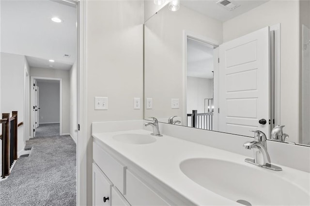 bathroom with double vanity, visible vents, and a sink