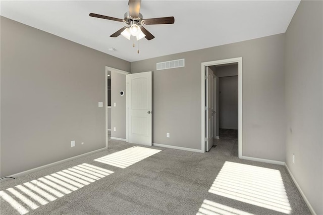 unfurnished bedroom with light colored carpet, a spacious closet, and ceiling fan