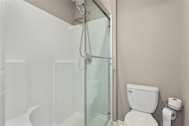 bathroom featuring an enclosed shower and toilet