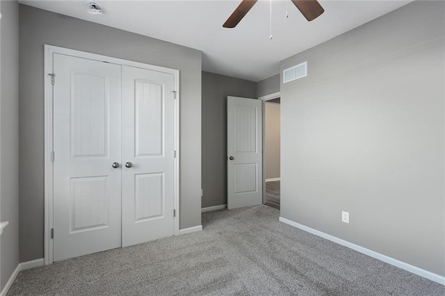 unfurnished bedroom with ceiling fan, light colored carpet, and a closet