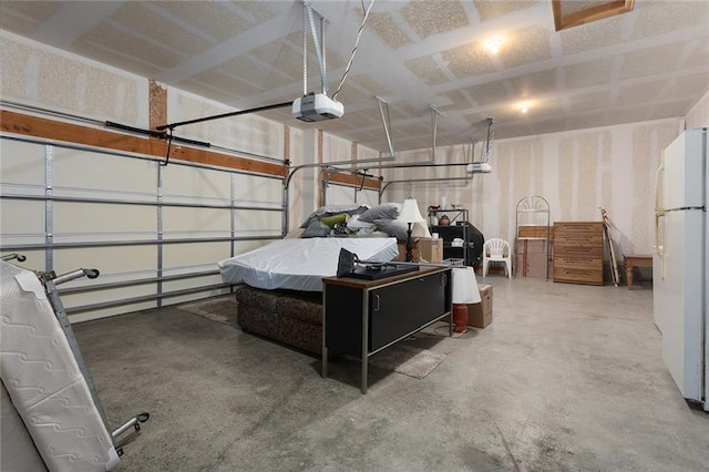 garage featuring white fridge and a garage door opener