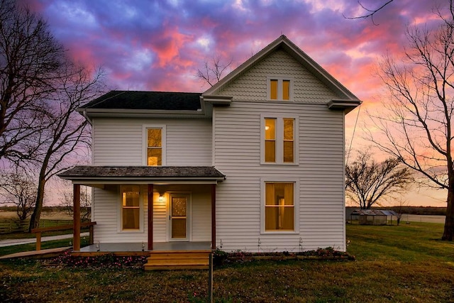 view of front of home featuring covered porch and a yard