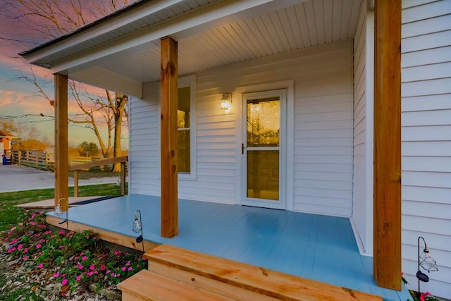 exterior entry at dusk featuring a porch