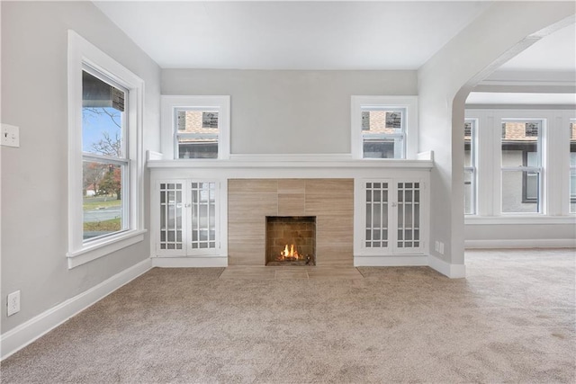 unfurnished living room with carpet floors and a wealth of natural light