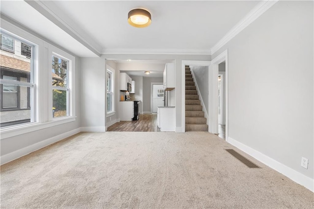 unfurnished living room featuring carpet flooring and crown molding