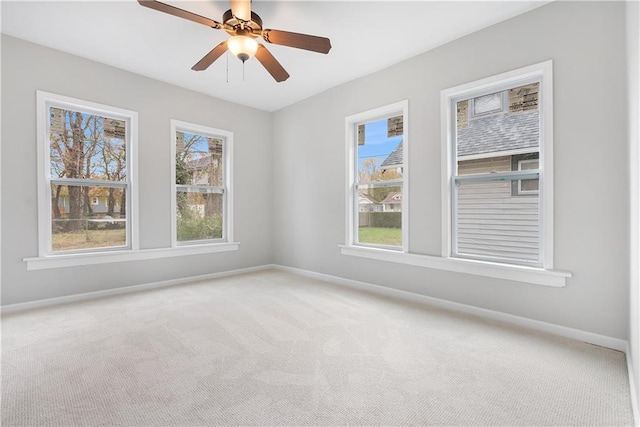 unfurnished room with a wealth of natural light, carpet floors, and ceiling fan