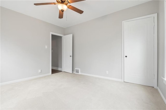 unfurnished bedroom with ceiling fan and light colored carpet