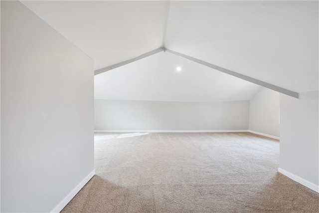 additional living space with carpet flooring and lofted ceiling