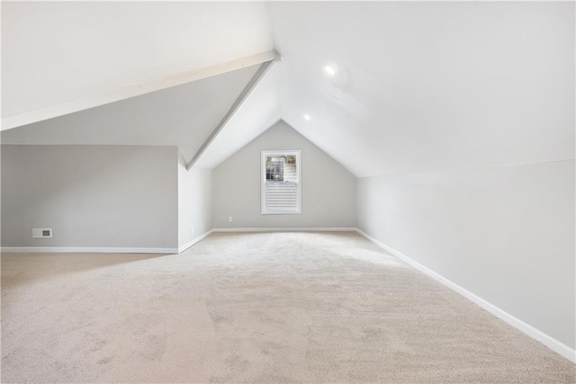 additional living space featuring light carpet and vaulted ceiling