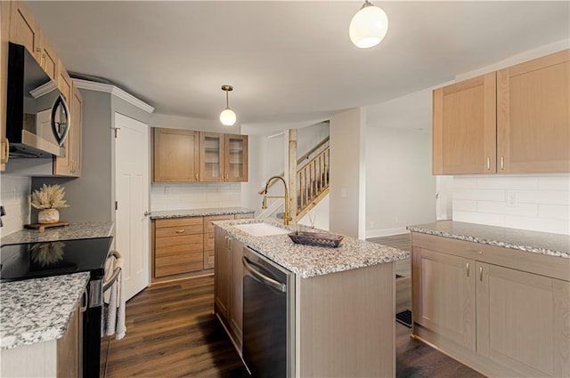 kitchen featuring pendant lighting, sink, an island with sink, appliances with stainless steel finishes, and dark hardwood / wood-style flooring