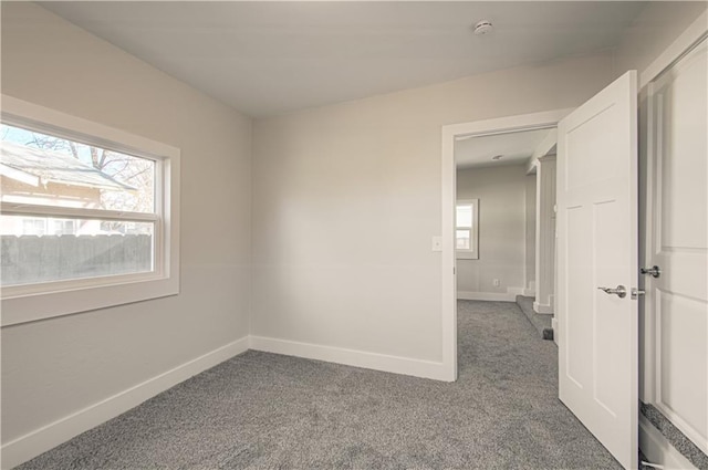 empty room featuring a wealth of natural light and carpet floors