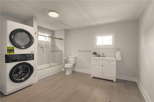 washroom featuring sink, light hardwood / wood-style floors, and stacked washer / drying machine