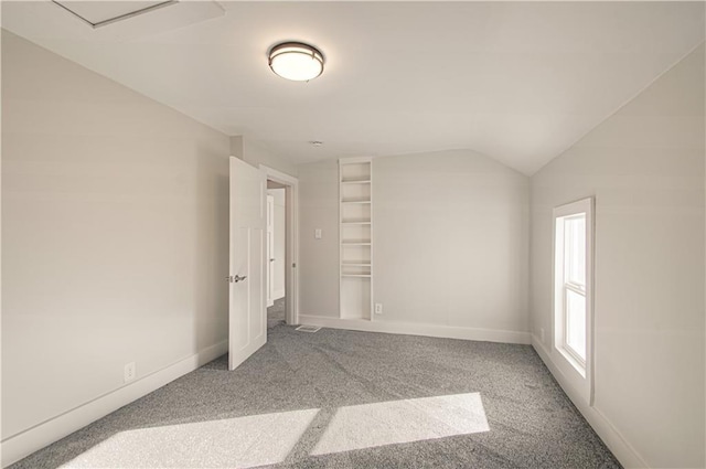 carpeted empty room featuring vaulted ceiling