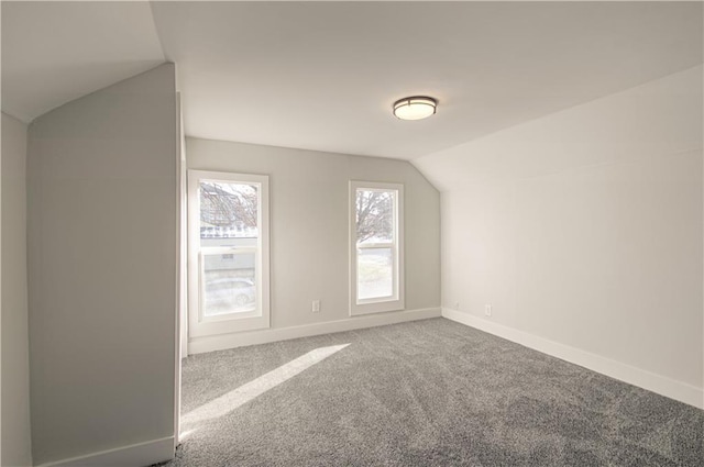 additional living space featuring carpet floors and vaulted ceiling