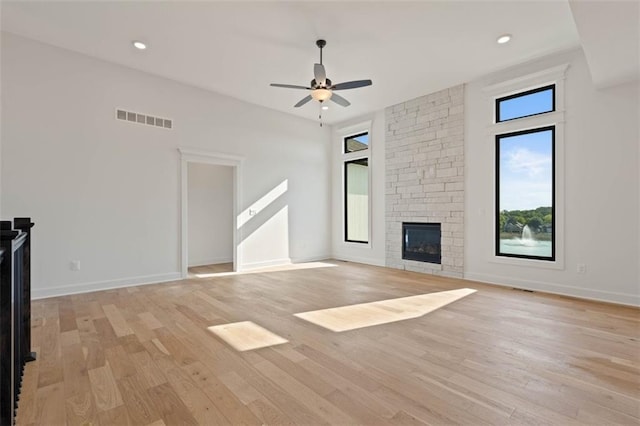 unfurnished living room featuring light wood-type flooring, ceiling fan, and a fireplace