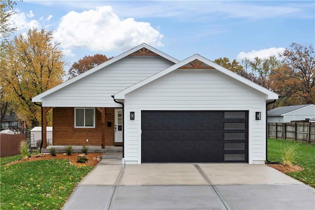 view of front of home featuring driveway, a front yard, a garage, and fence