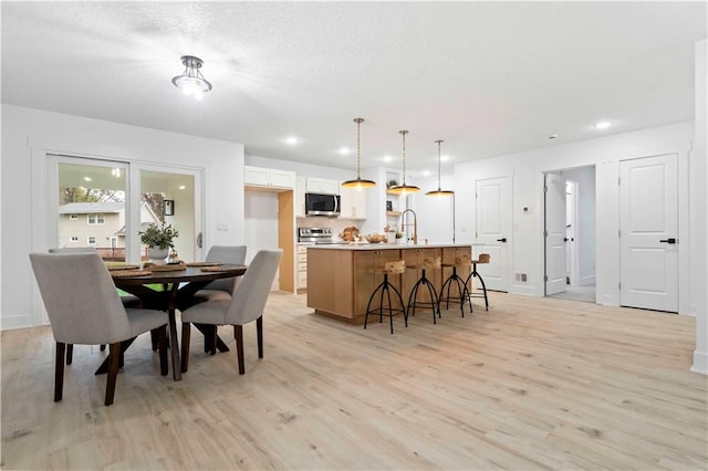 dining space featuring light hardwood / wood-style flooring and sink