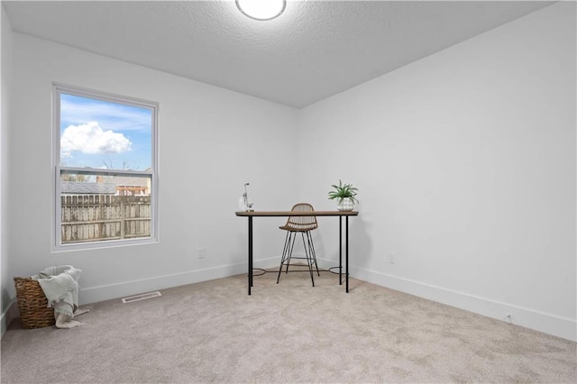 unfurnished room featuring visible vents, a textured ceiling, baseboards, and carpet floors