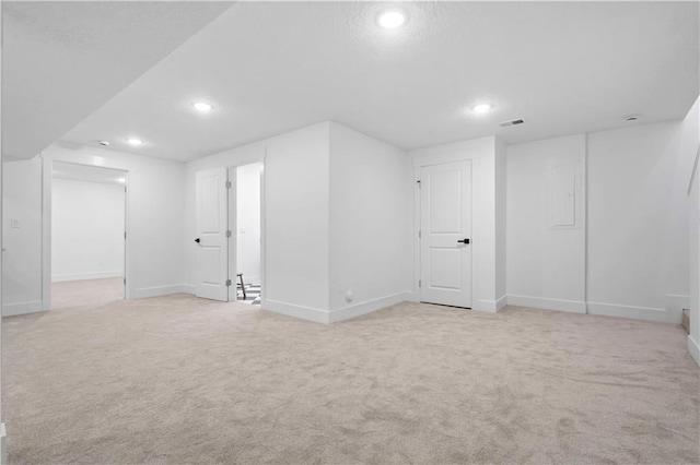 below grade area featuring recessed lighting, baseboards, and light carpet