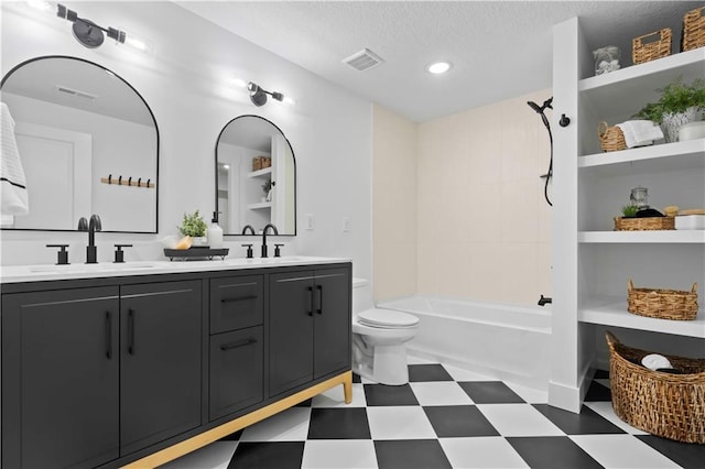 full bathroom featuring vanity, a textured ceiling, tiled shower / bath combo, and toilet