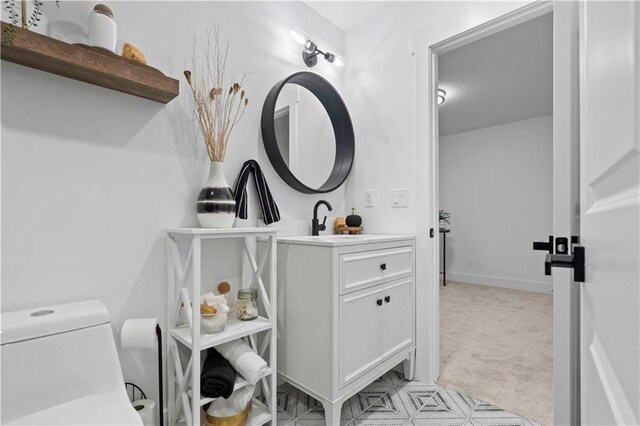 bathroom with vanity, toilet, and baseboards