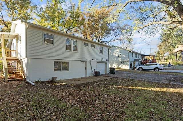 rear view of house featuring a garage and central air condition unit