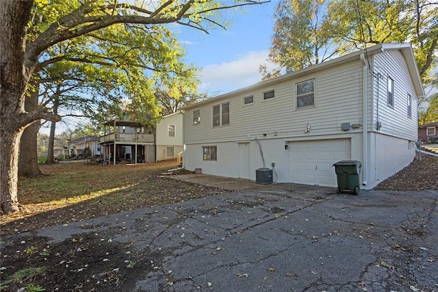 back of property with a garage and a wooden deck