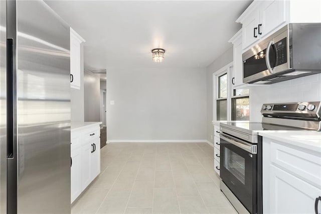 kitchen featuring tasteful backsplash, white cabinets, and stainless steel appliances