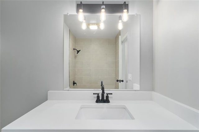 bathroom with a tile shower and vanity