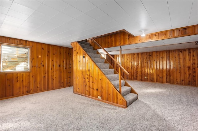 basement with carpet flooring and wood walls