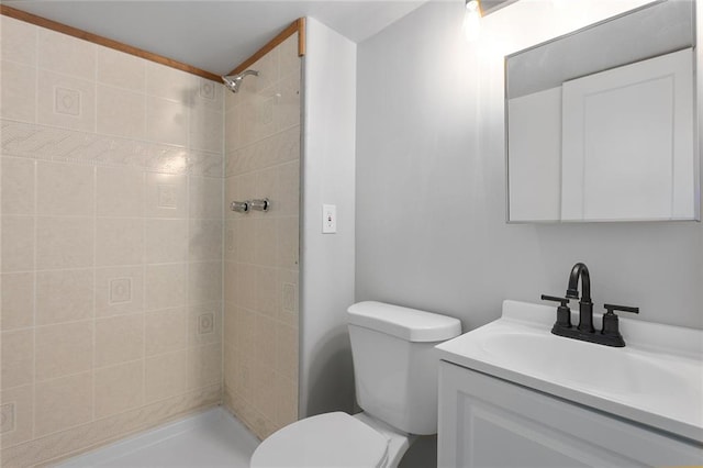 bathroom with vanity, toilet, and a tile shower