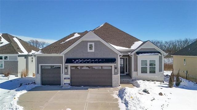 view of front facade featuring a garage, driveway, roof with shingles, and stucco siding