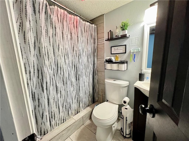 bathroom with toilet, tile patterned flooring, a textured ceiling, vanity, and walk in shower