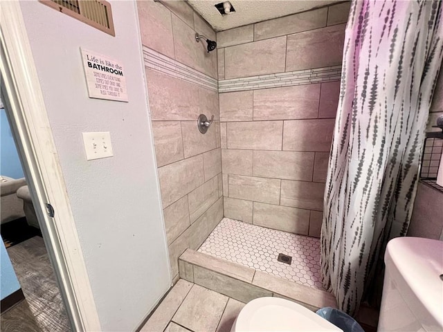 bathroom with toilet, a shower with shower curtain, and tile patterned floors