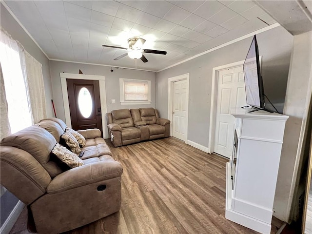 living room with light wood-type flooring, ceiling fan, and crown molding