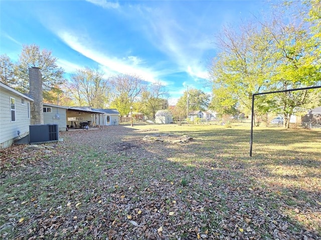 view of yard featuring central AC unit and a storage unit