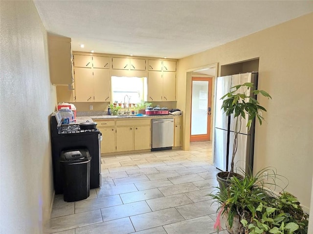 kitchen featuring cream cabinetry, sink, and appliances with stainless steel finishes