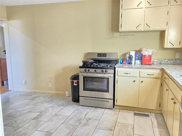 kitchen with cream cabinetry and stainless steel gas range