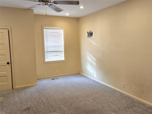 carpeted spare room with ceiling fan