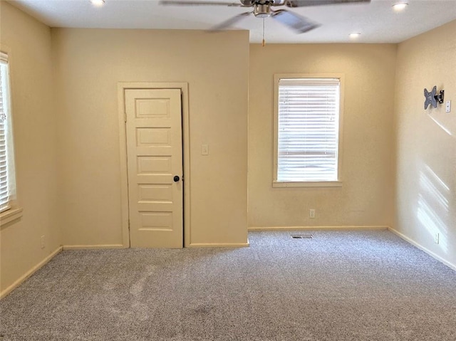 carpeted spare room with ceiling fan