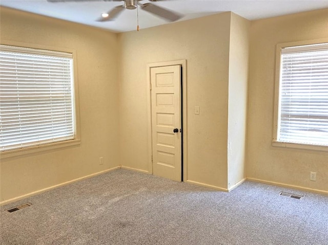 carpeted spare room featuring ceiling fan