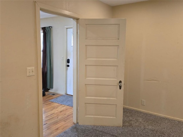 hallway with hardwood / wood-style floors