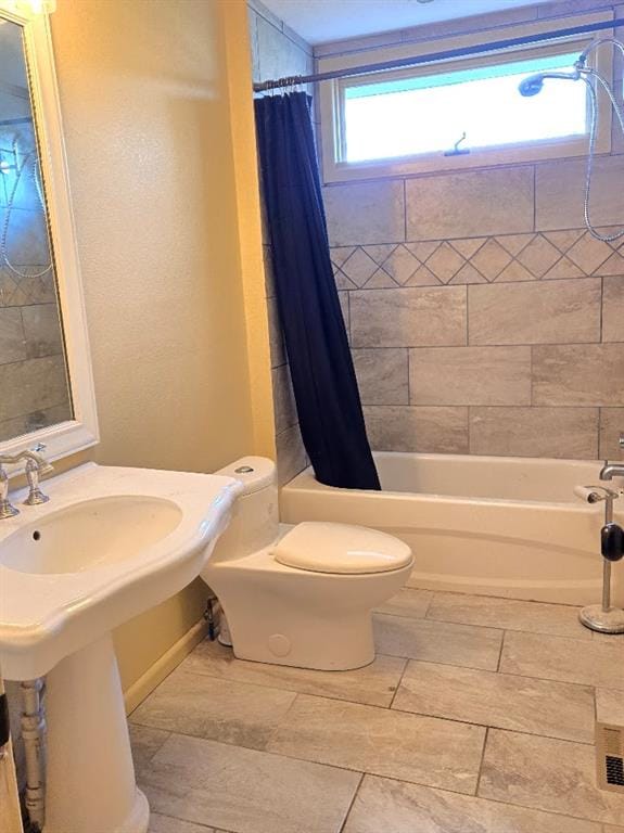 full bathroom featuring toilet, shower / bath combo with shower curtain, and sink