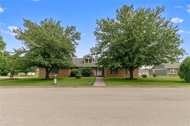 view of property hidden behind natural elements with a front lawn