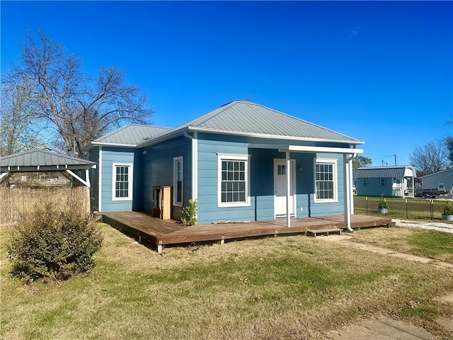 rear view of property featuring a deck and a yard