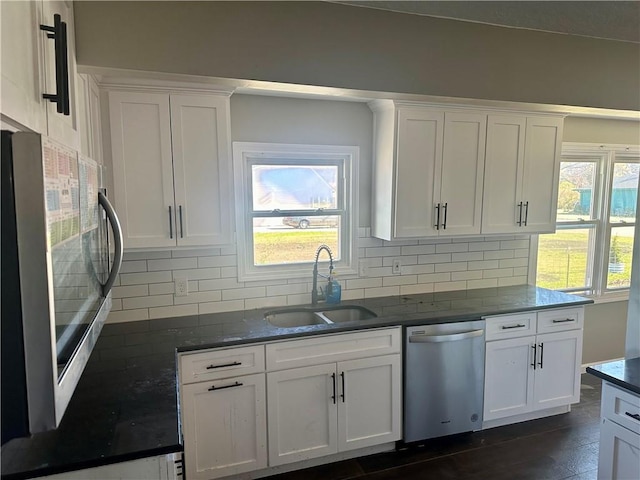 kitchen with white cabinetry, appliances with stainless steel finishes, sink, and backsplash