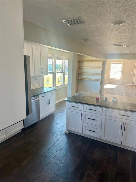 kitchen featuring white cabinets, a wealth of natural light, dark hardwood / wood-style flooring, and tasteful backsplash